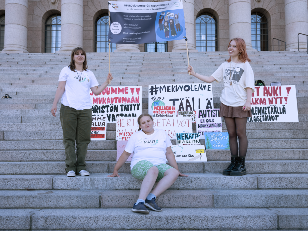 Nuoret aktivistit Paju Klemole, Aida Abdelgayed ja Paula Hautaniemi eduskuntatalon portailla.