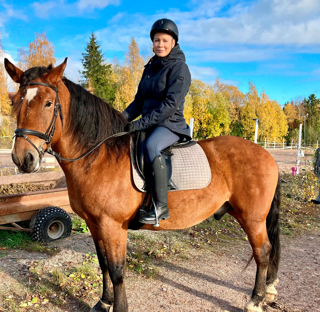 Nainen hevosen selässä.