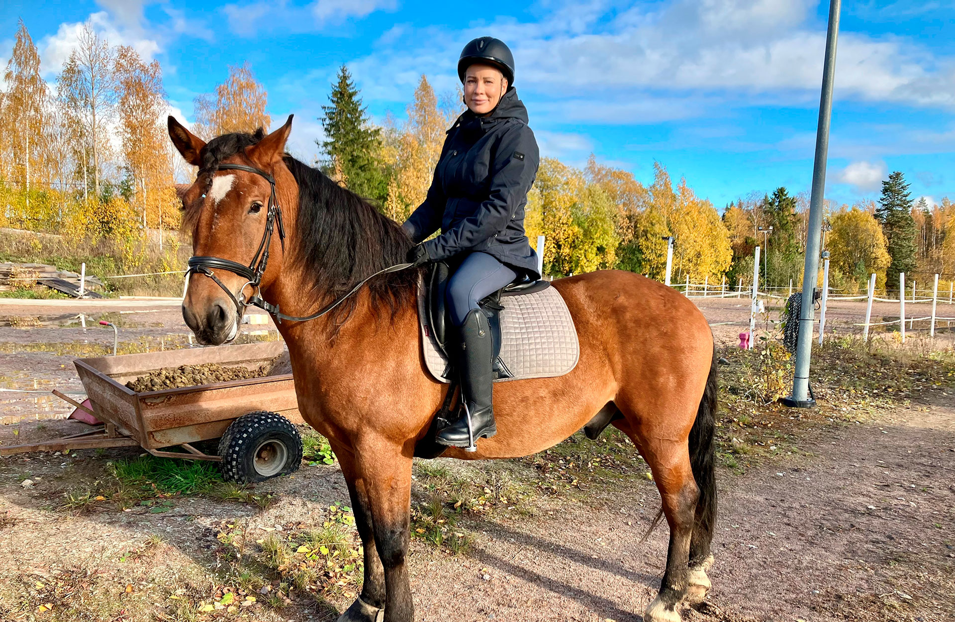 Nainen hevosen selässä.