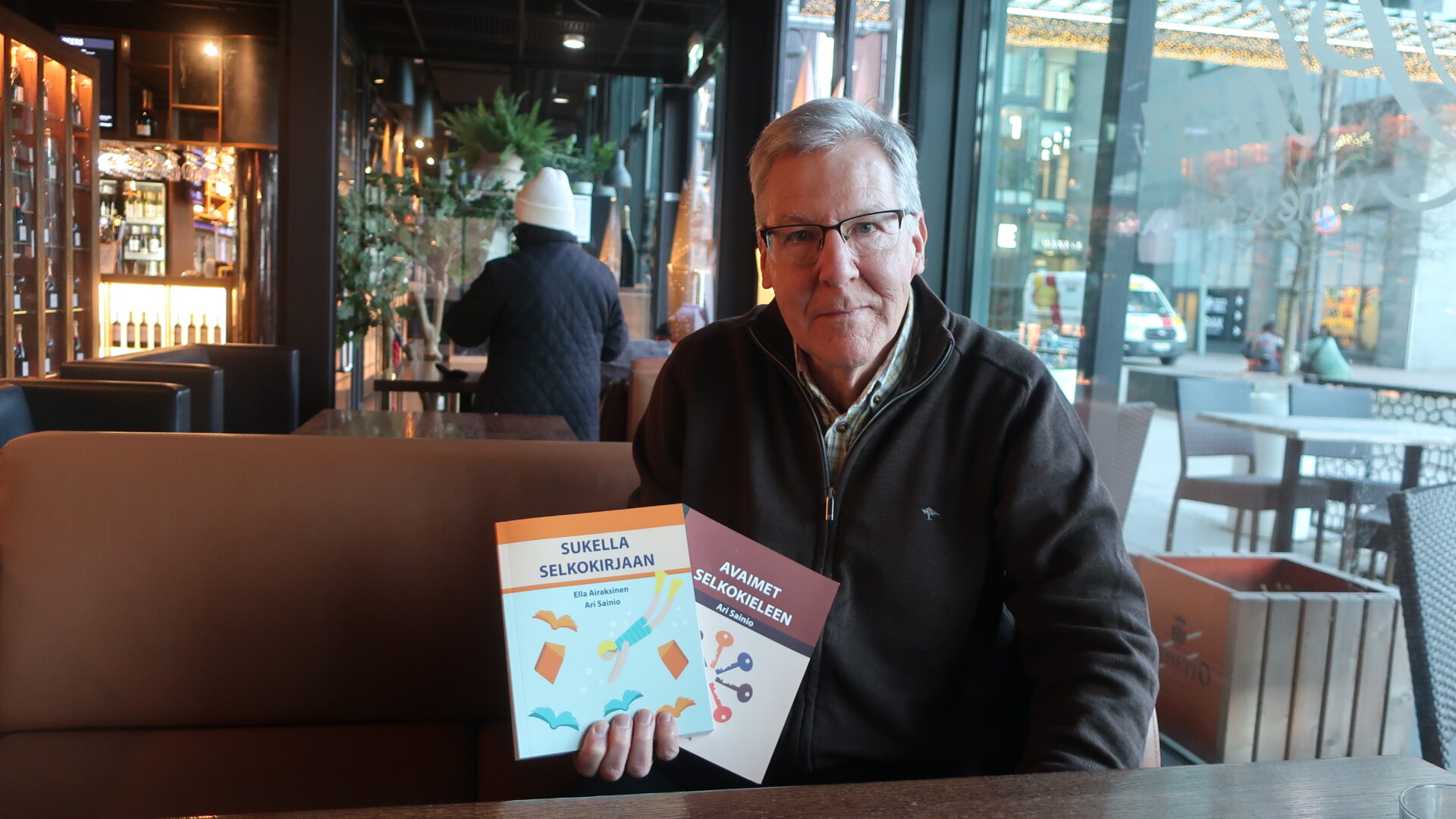 Mies pitelee kädessään kahta selkokielellä kirjoitettua kirjaa.