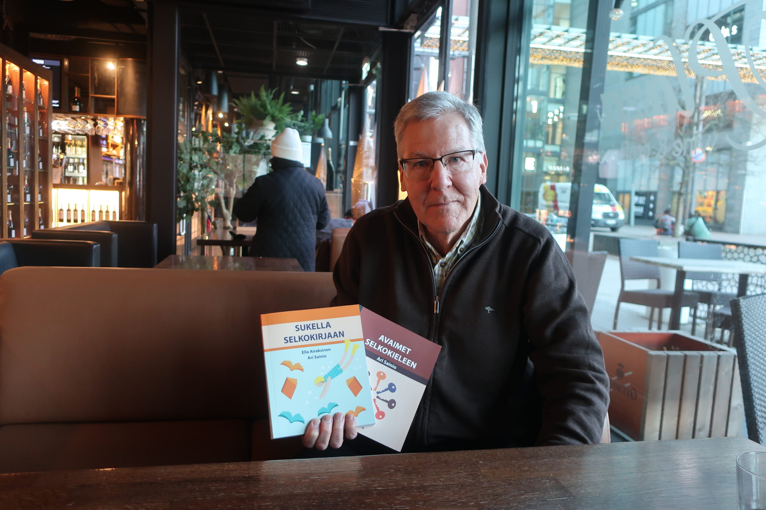 Mies pitelee kädessään kahta selkokielellä kirjoitettua kirjaa.