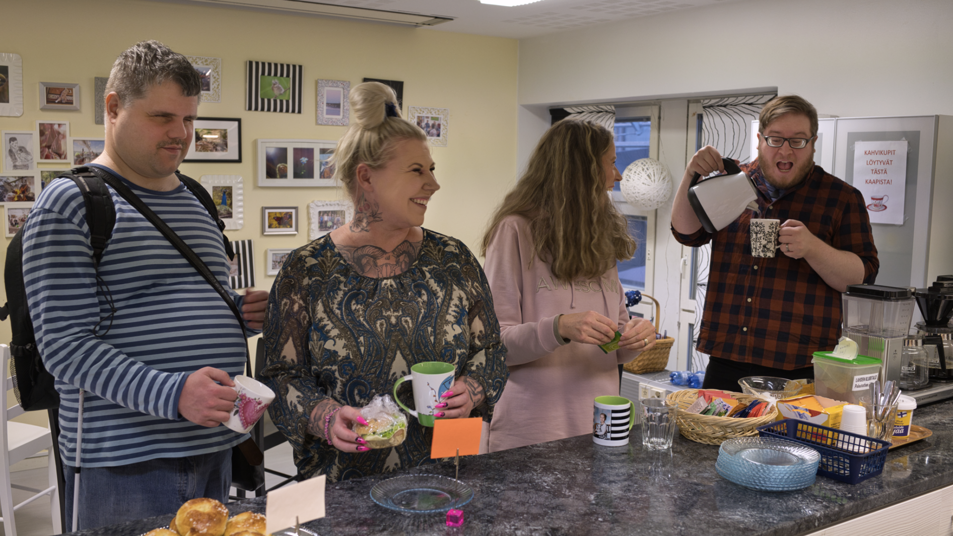 Iloisia ihmisiä kahvipöydän ympärillä.