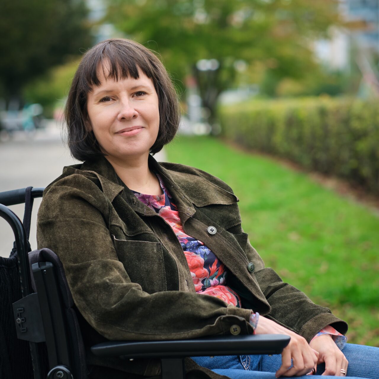 Päivi Montgomery kuvattuna ulkona pyörätuolissa.