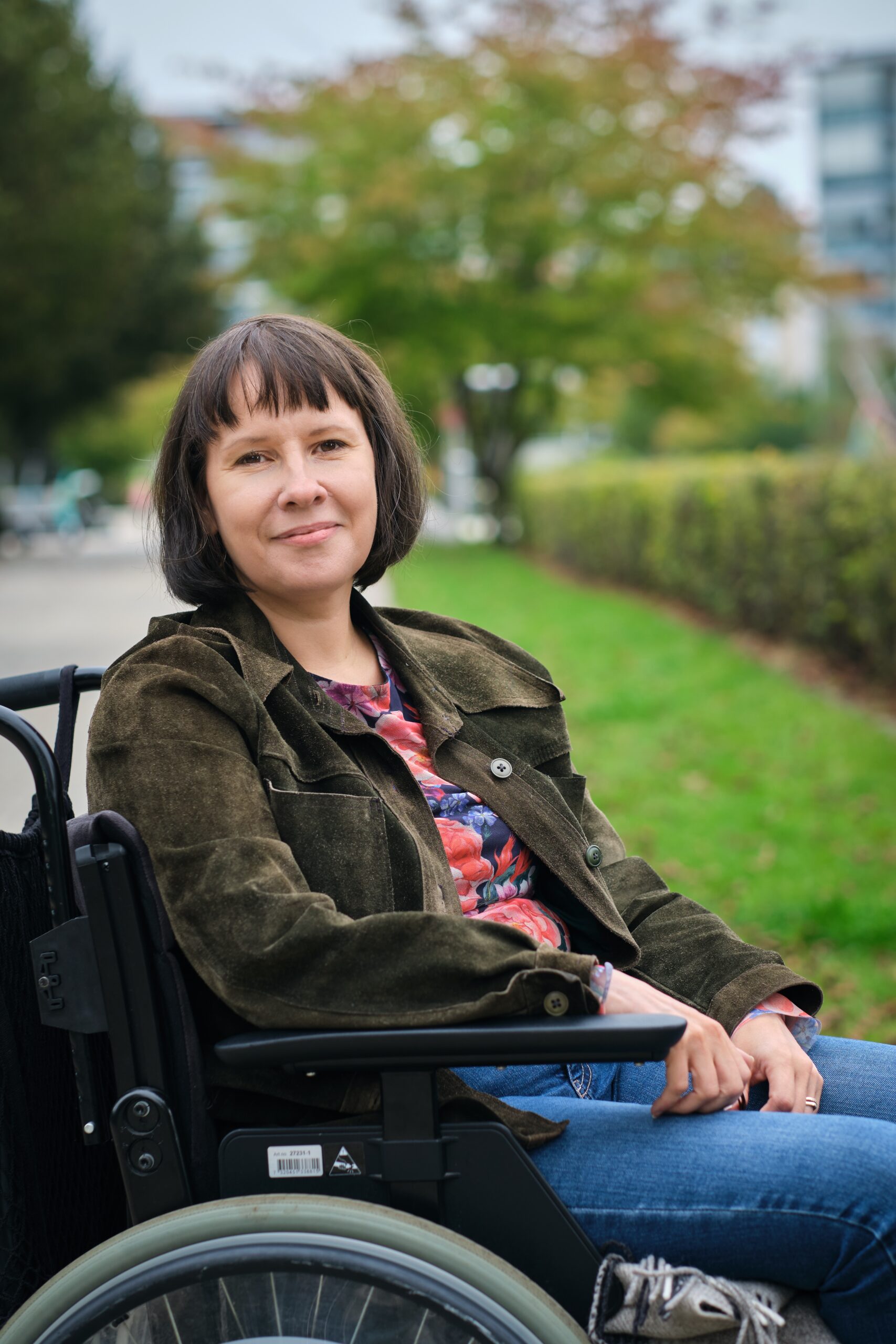 Päivi Montgomery kuvattuna ulkona pyörätuolissa.