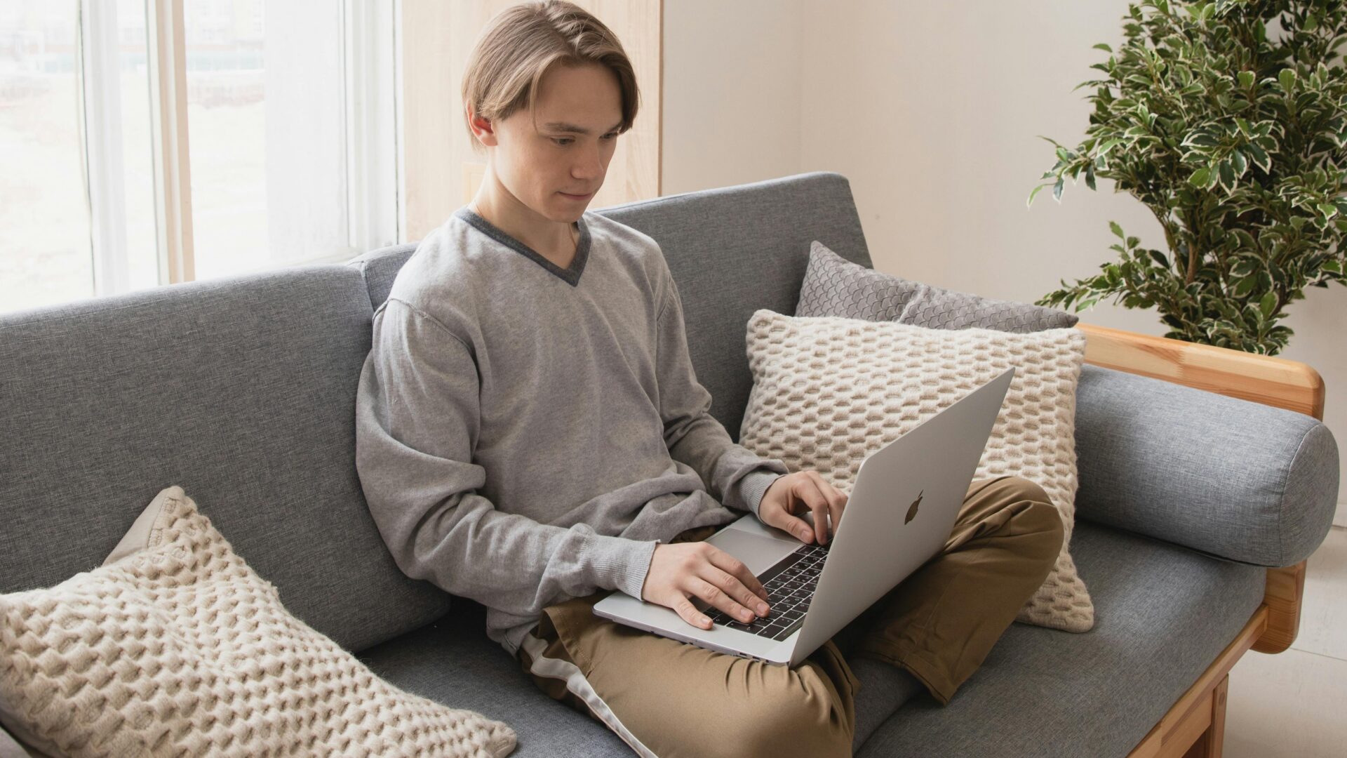 Mies istuu sohvalla läppäri sylissään.