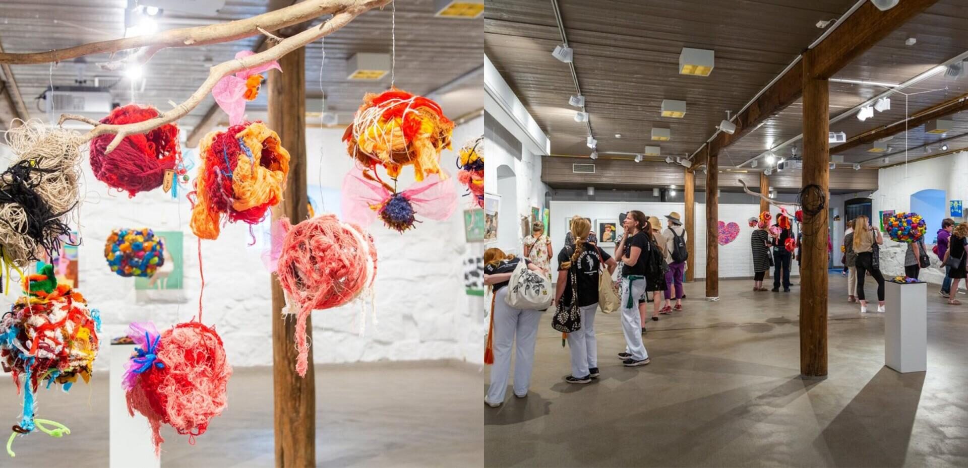 Taidenäyttely, jossa ihmiset katsomat erilaisia maalauksia.