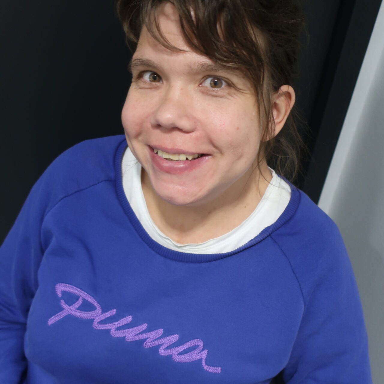 Nainen sinisessä Puma-merkkisessä paidassa.