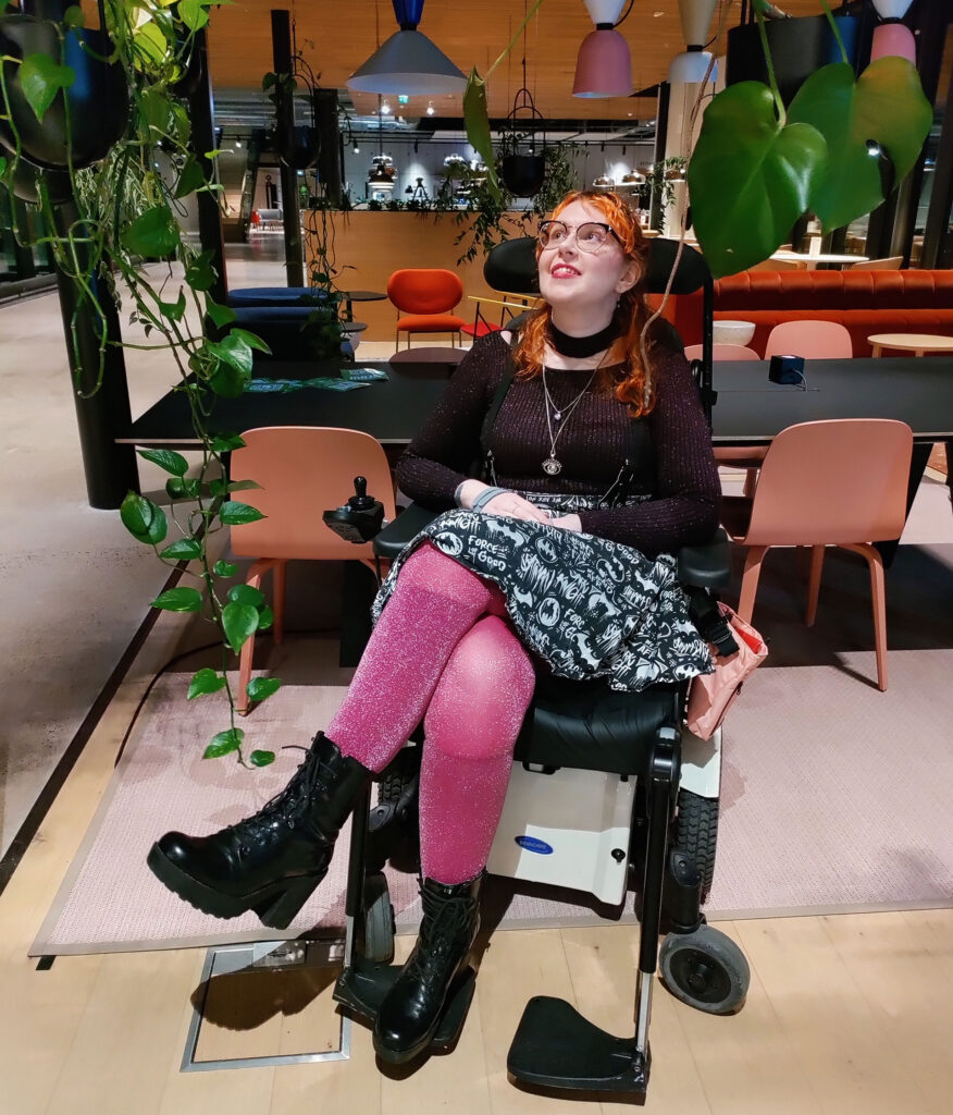 Oona Tontti pyörätuolissaan ravintolamiljöössä