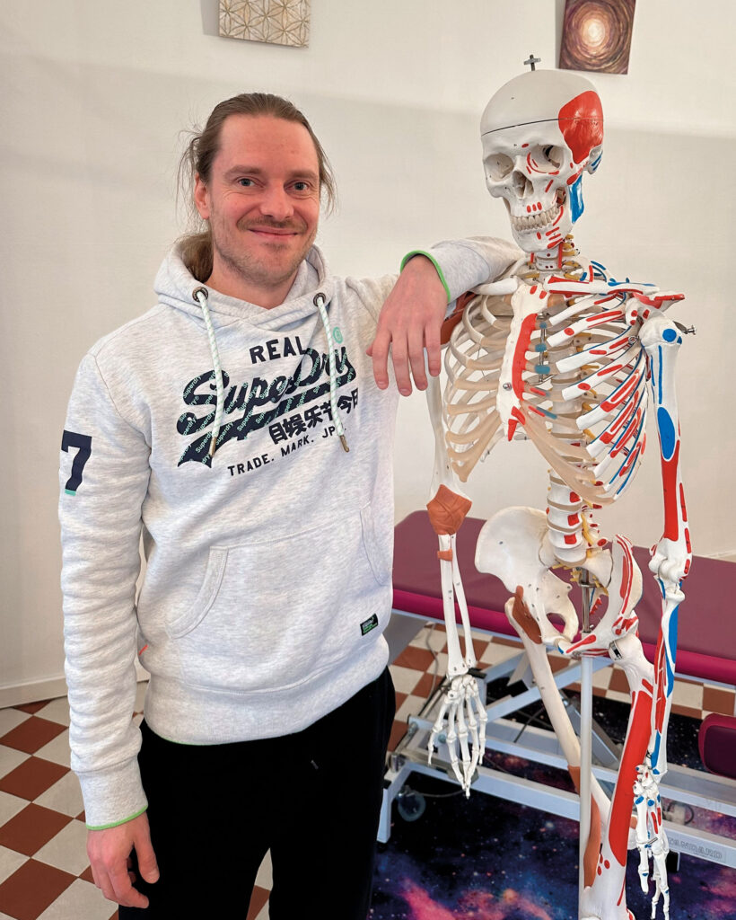 Ville Vertanen nojaa kehon anatomiaa havainnollistavaan luurankomalliin.