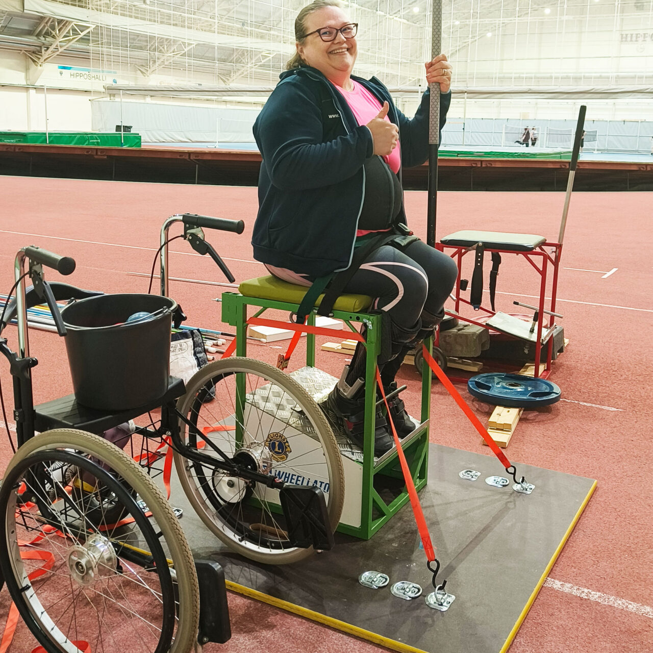 Elina Miettinen istuu heittotuolissaan urheiluhallissa.