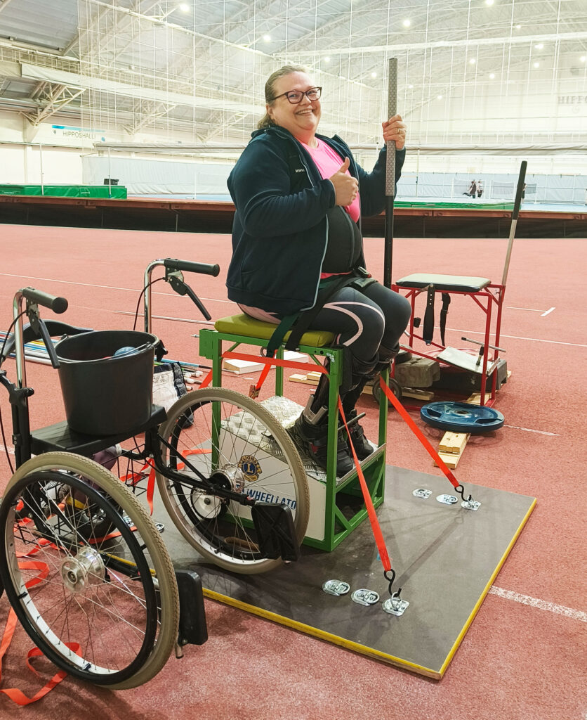 Elina Miettinen istuu heittotuolissaan urheiluhallissa.