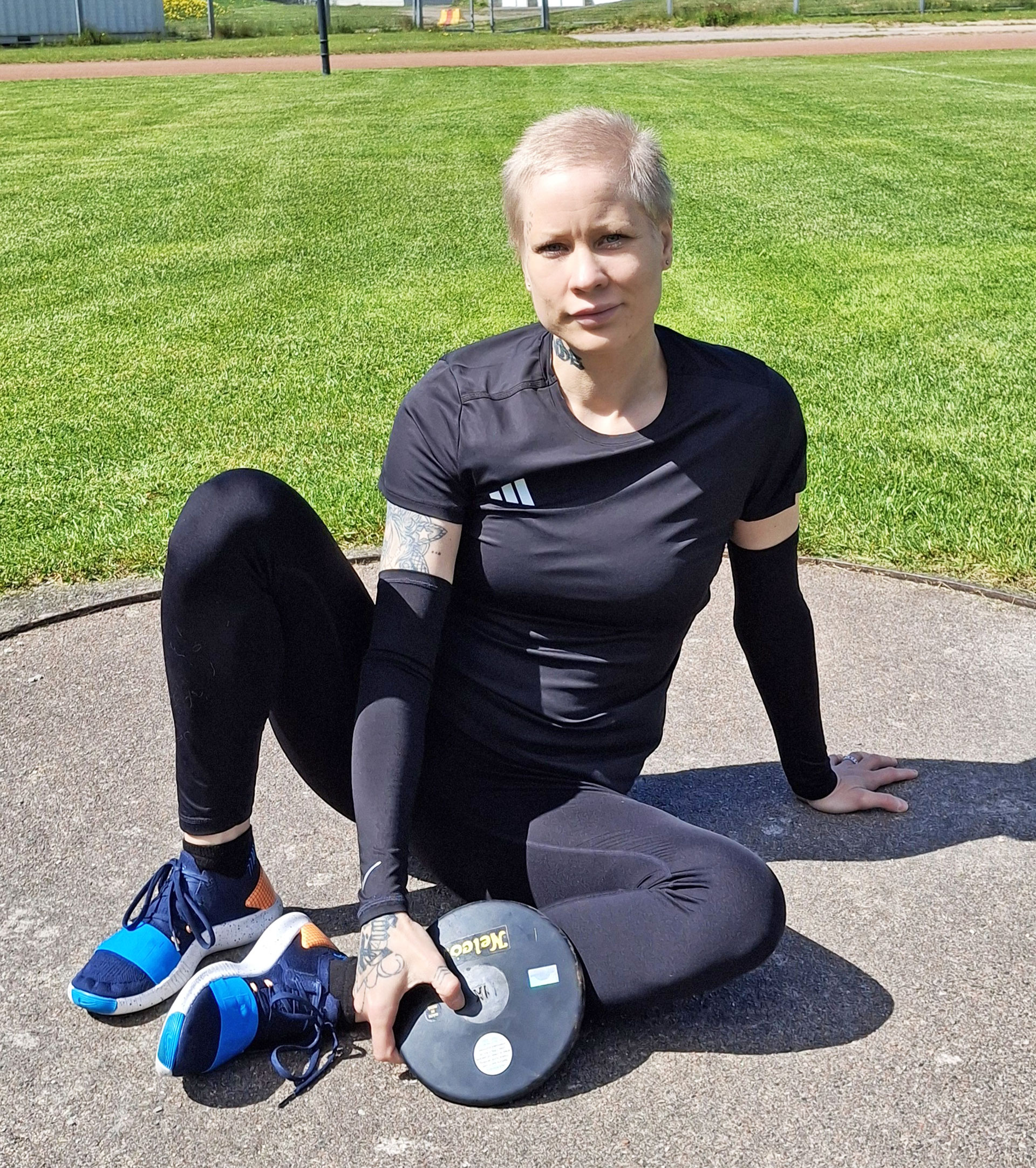 Maaria Laiho istuu kiekon kanssa kiekonheittokehässä.